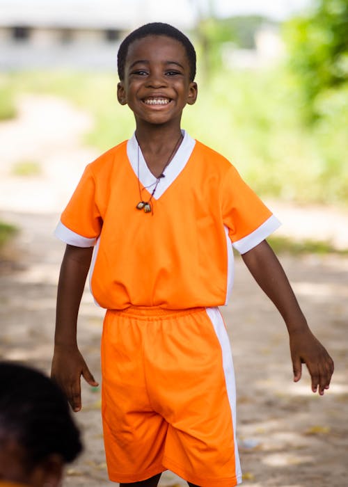 Little Boy in Orange and White Shirt Smiling