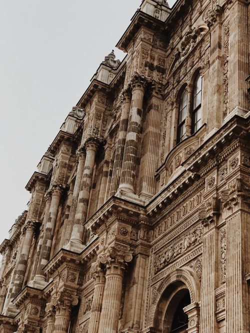 Free Low angle view of an ornate historic building facade with pillars in a classic architectural style. Stock Photo