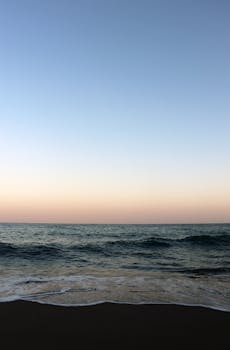 Beautiful sunset seascape at Nerja Beach, Andalucia, Spain. Calm waves and pastel sky.