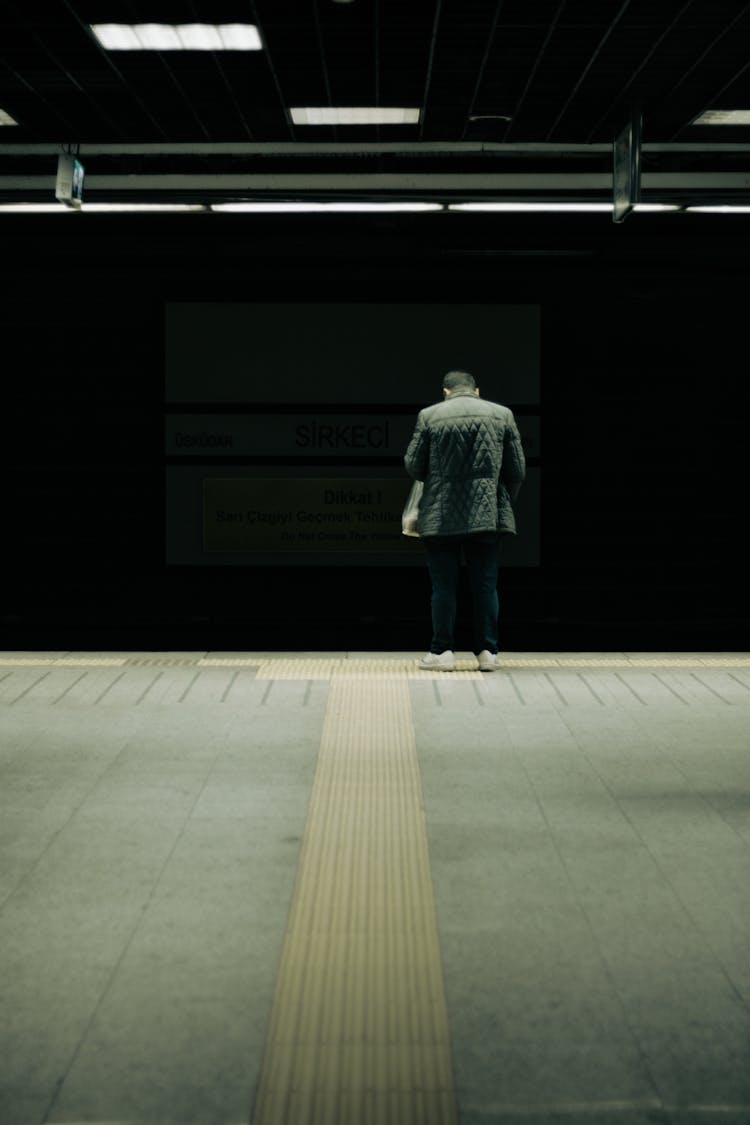 Back Of A Man Standing At A Metro Station