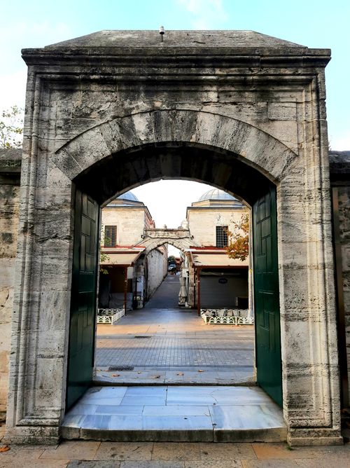 Free Explore a historic stone archway leading to shops in Istanbul's Fatih district. Stock Photo