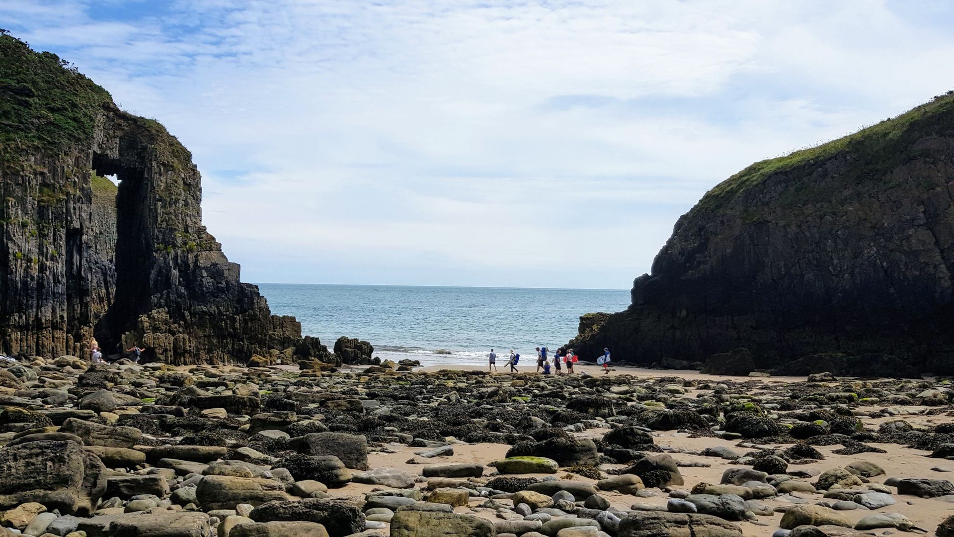 Explore the dramatic rocky beach landscape at Manorbier, Wales with coastal cliffs.