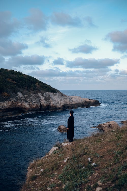 Person Standing on a Rocky Coast 