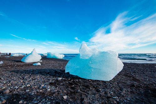 Free Icy formations on a black sand beach under a clear blue sky, showcasing natural beauty. Stock Photo