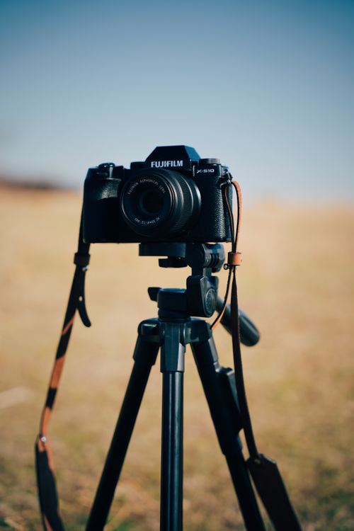Free A Fujifilm camera mounted on a tripod against a natural outdoor backdrop. Stock Photo