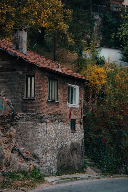 Free Old stone house amidst colorful autumn foliage on a secluded hillside. Stock Photo