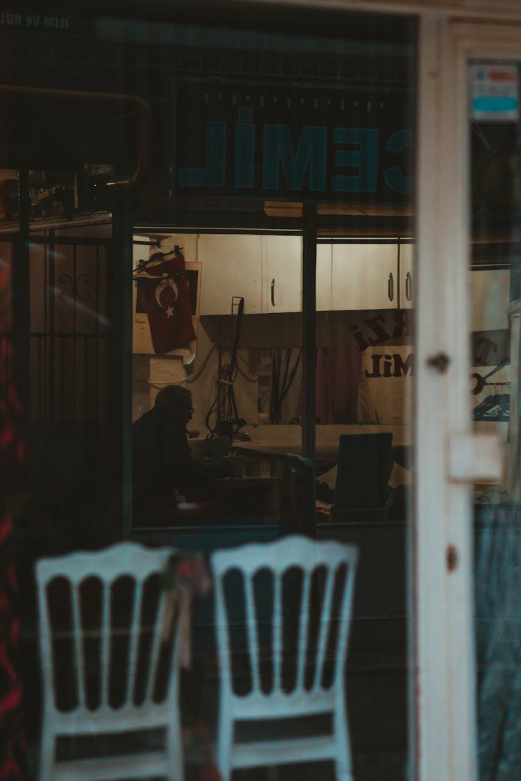 Silhouette Of Man Working Inside A Shop