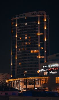 A tall building illuminated with lights at night, showcasing modern architecture and urban design.