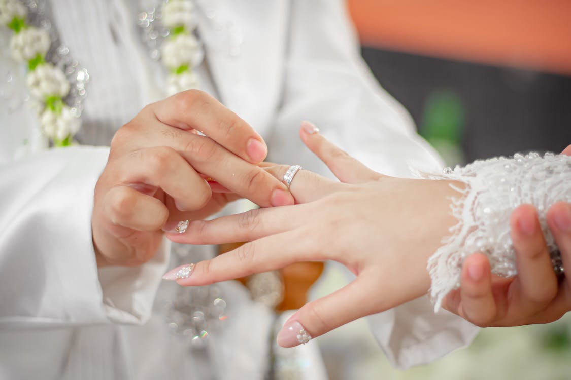 Free A Groom Putting a Wedding Ring on the Bride's Finger Stock Photo