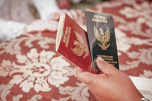 Hands holding Indonesian marriage books during a traditional wedding ceremony.
