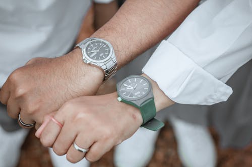 Person Wearing Silver Round Analog Watch With Green Strap