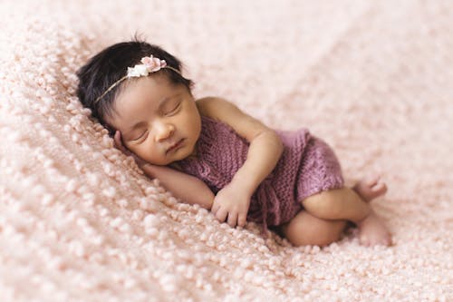 Criança Deitada Na Almofada De Lã Rosa