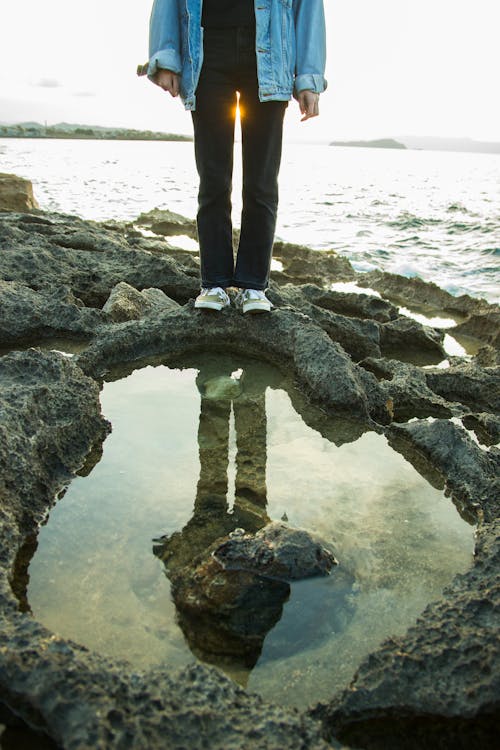 Girl Standing above a Puddle on a Beach 