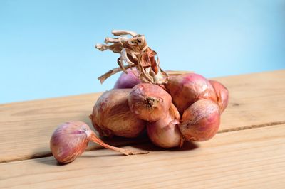 Fresh shallots on a wooden table — photo by Miguel Á. Padriñán on Pexels