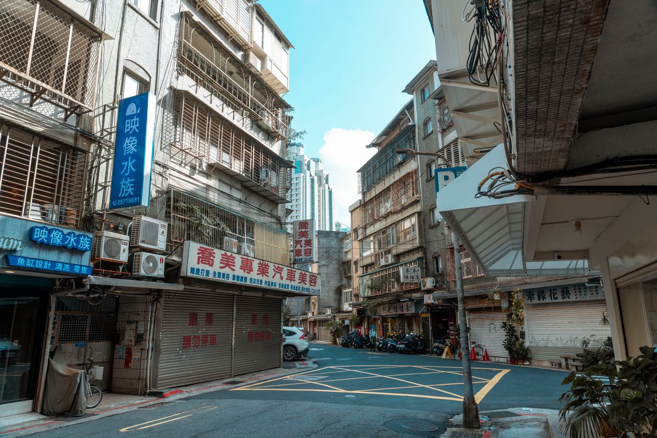 an empty street in a city showcasing buildings with chinese signboards