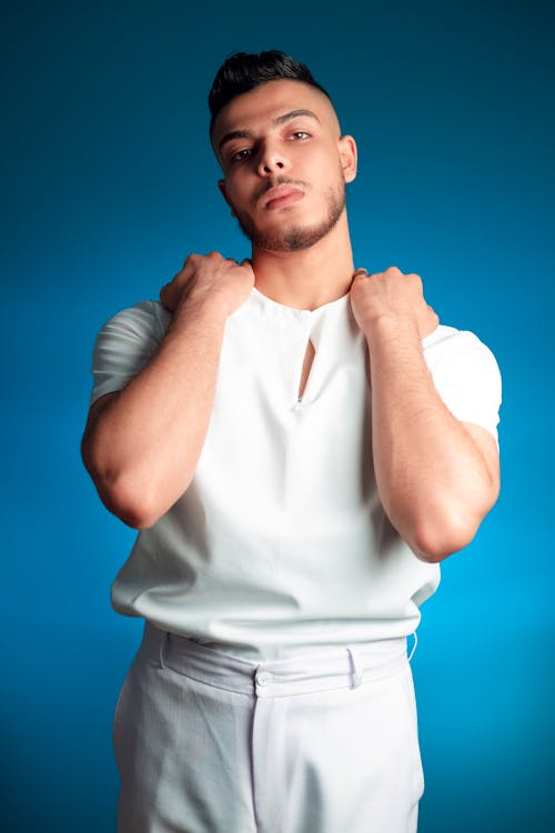 A Bearded Man in White Shirt with His Hands on His Shoulders