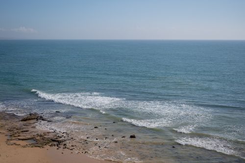 Free Serene beach and ocean view in Albufeira, Portugal, with gentle waves and a clear blue sky. Stock Photo