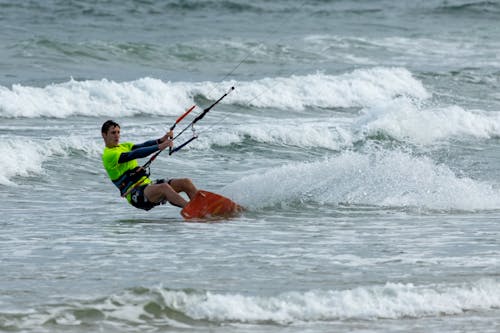 Man in Sportswear Having Fun Kiteboarding on Sea