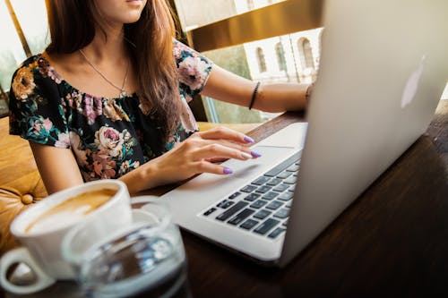 女人穿着使用她的苹果品牌macbook的鸡舍脖子花上衣