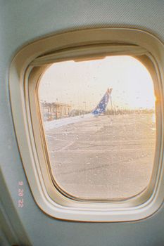 A scenic view of an airplane wing at sunset, captured from a window seat.