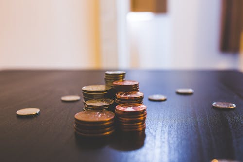 Free Pile of Brown Coins on Brown Wooden Table Top Stock Photo