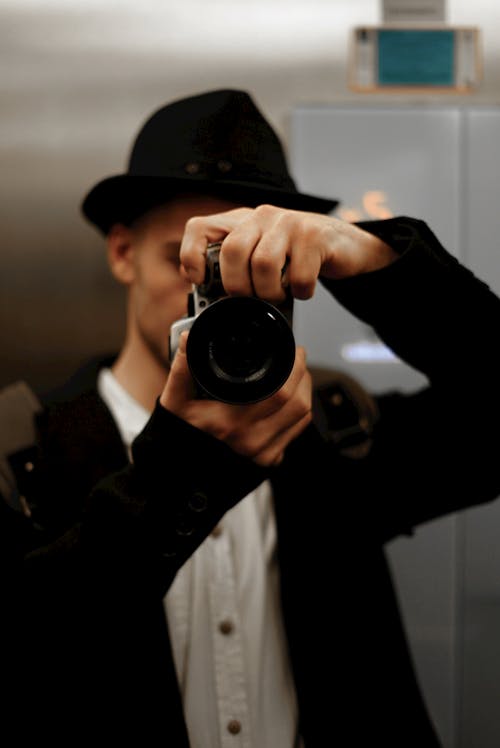 A Man in Black Suit Holding Camera