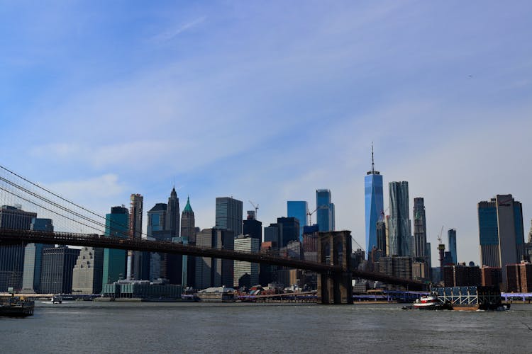 A City Buildings Near The Brooklyn Bridge Over The Hudson River