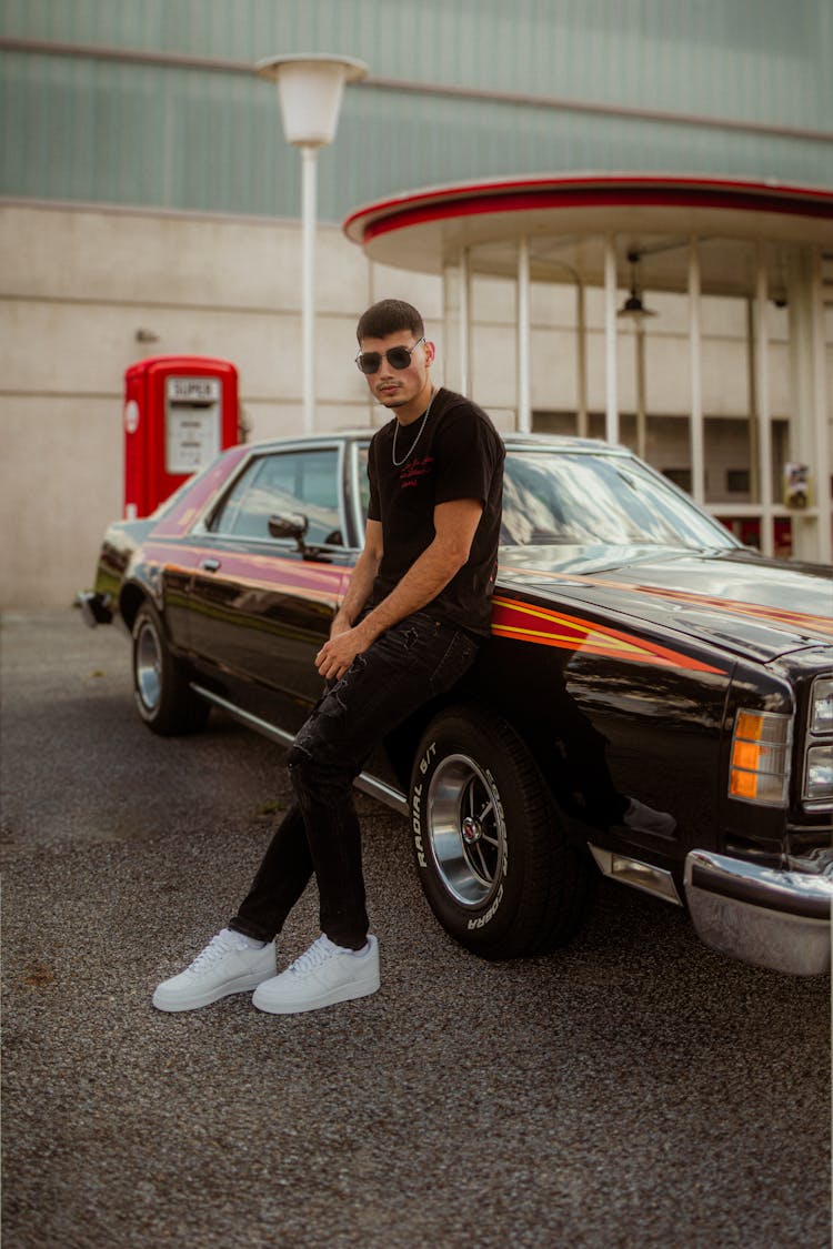 Man In Sunglasses Leaning Against Car