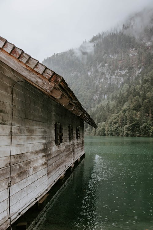 Brown Wooden Cabin Surrounded by Body of Water