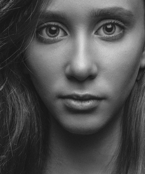 Free Monochrome close-up portrait of a woman with a serious expression, showcasing intricate facial details. Stock Photo