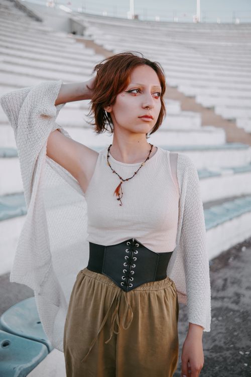 Free Stylish woman posing outdoors in an amphitheater setting, showcasing modern fashion. Stock Photo