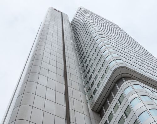 Free Low angle view of a futuristic skyscraper in Frankfurt, Germany, against a cloudy sky. Stock Photo