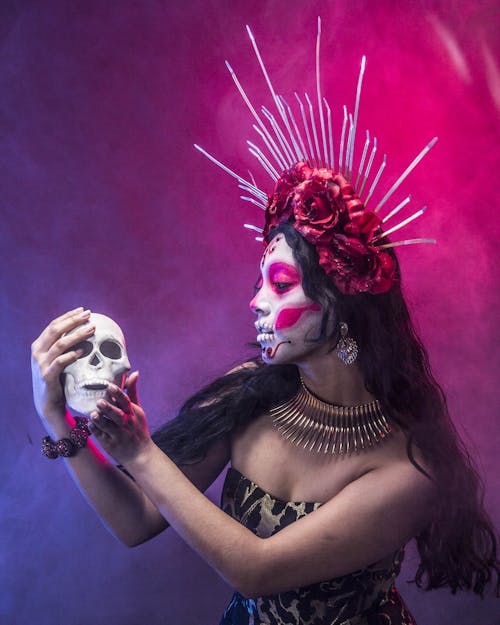 Woman Posing with Painted Face and Holding Skull