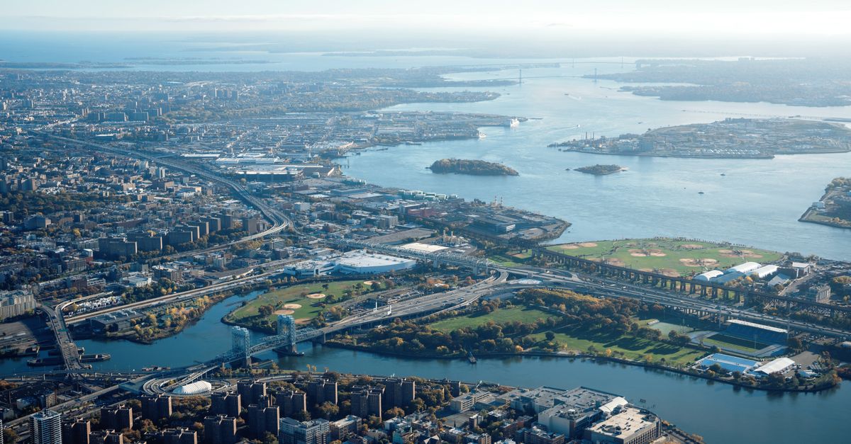 Aerial shot capturing the sprawling cityscape and waterways with bridges and islands.
