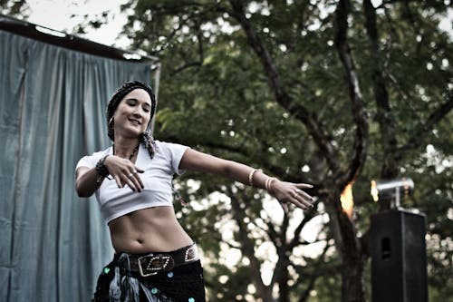 Woman Dancing Near Green Leafed Tree