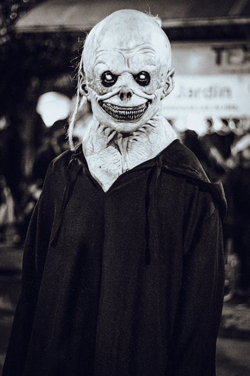 Person Wearing a Scary Halloween Mask Standing on a Street 