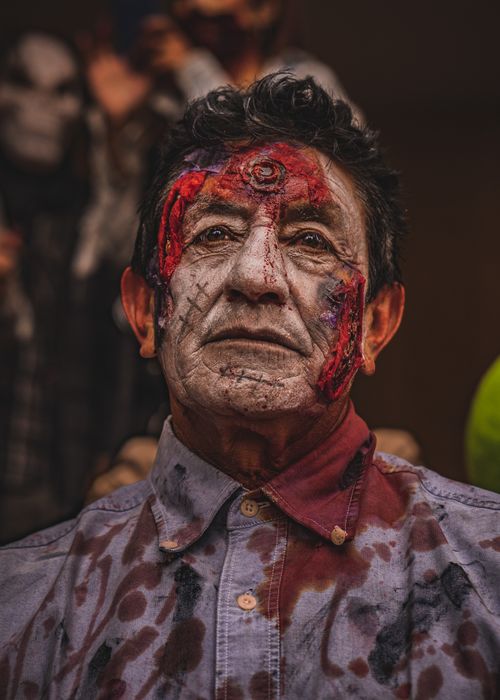 Free Detailed portrait of a man dressed as a zombie with face makeup and bloodstained clothing for Halloween. Stock Photo