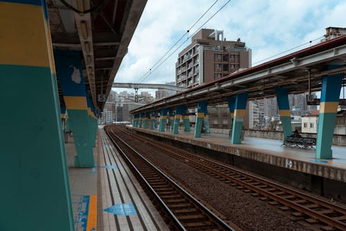 An Empty Train Tracks Between Railway Platform