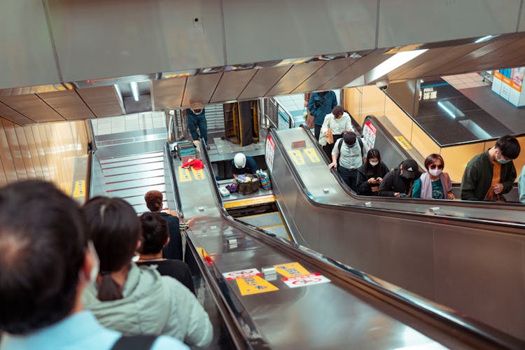 People Riding At Escalator