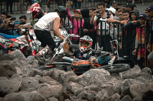 Free Motocross riders navigate rocky terrain in a thrilling race event in Yogyakarta. Stock Photo