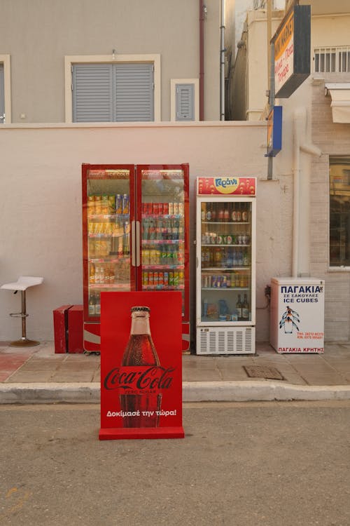 White and Red Vending Machines Near the Concrete Building