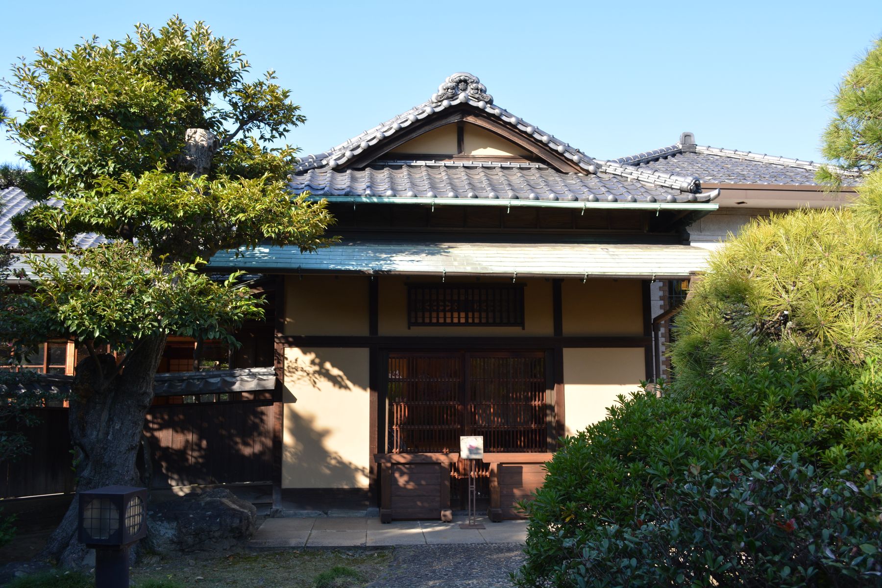 Traditional Japanese house exterior with a tiled roof, timber facade and garden