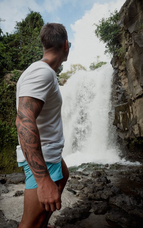 A Man Standing Near a Waterfall 