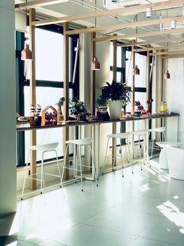 A modern café interior featuring sleek bar stools, pendant lighting, and elegant decor, perfect for a contemporary setting.