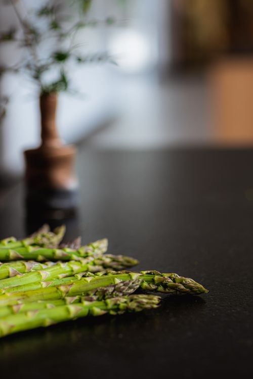 Free Vibrant fresh asparagus spears arranged on a dark countertop, perfect for culinary themes. Stock Photo