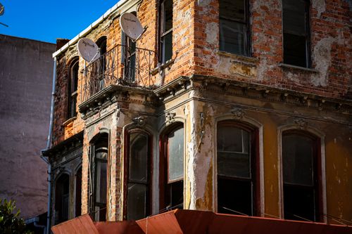 Free Aged brick building with intricate balcony design, showcasing urban architectural history. Stock Photo