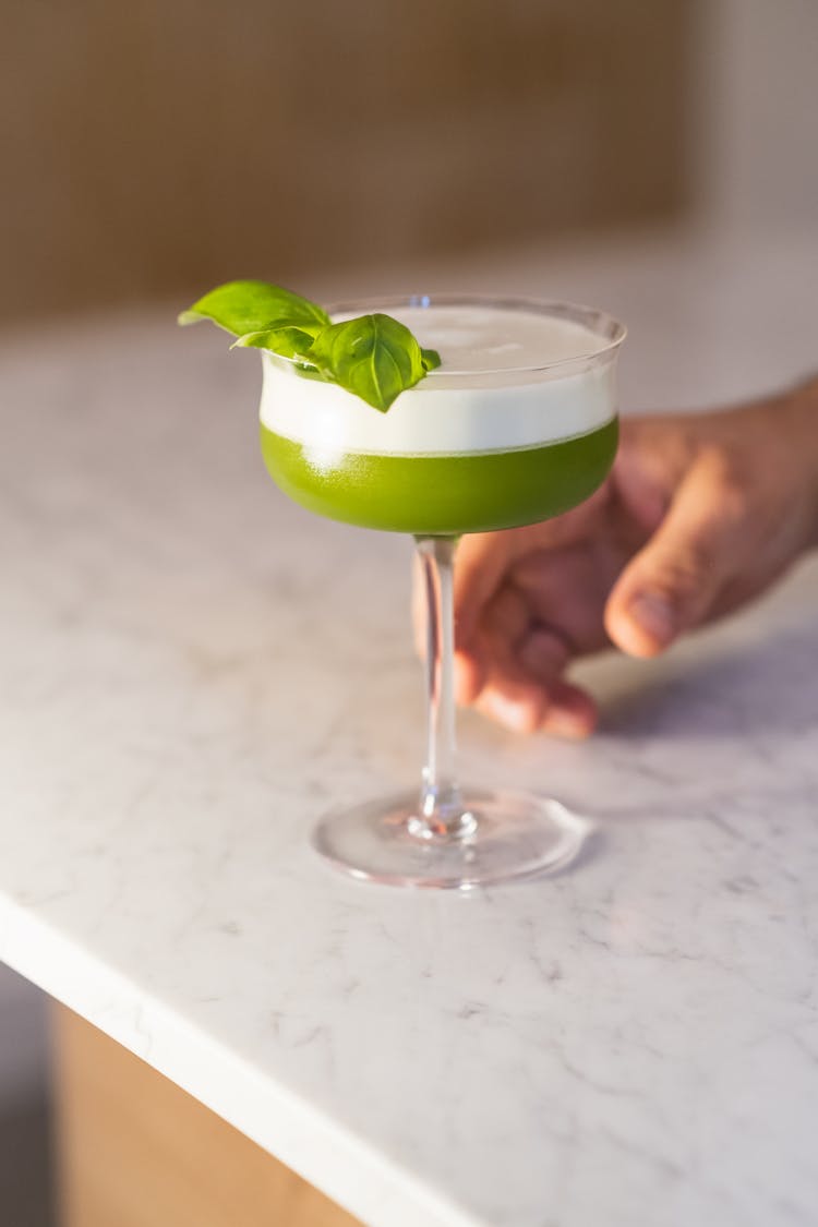 A Cocktail Drink With Basil Leaves