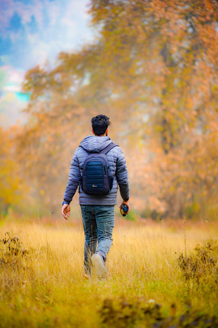 A Man With A Backpack In A Forest 