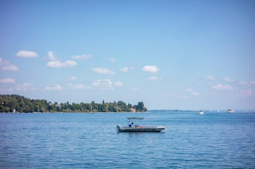 Kostnadsfri bild av båt, blå himmel, gröna träd