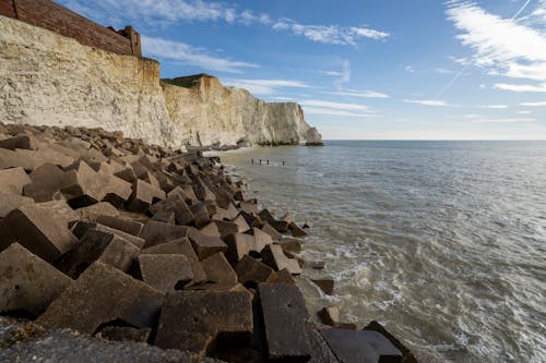 A Rocky Shore on the Beach Under the Blue Sky and White Clouds